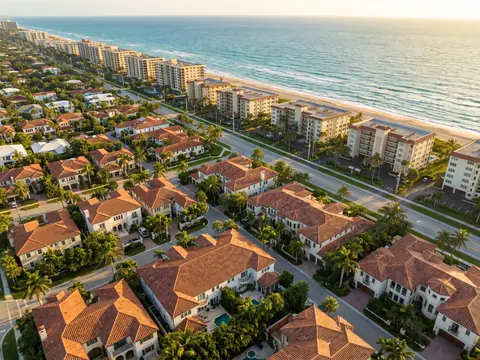 Aerial view of clay tile roofs and beachfront condominium towers on the Atlantic