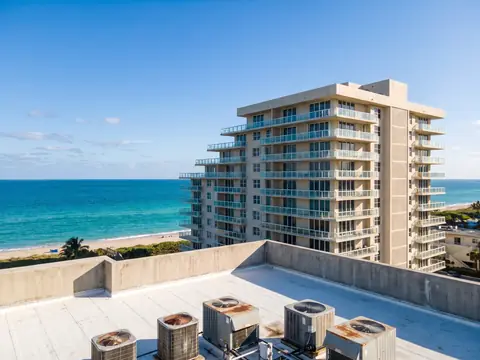 Oceanfront condominium tower seen from a flat roof with air-conditioning units