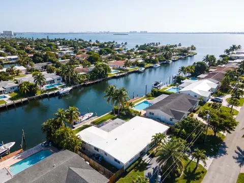Aerial view of flat and shingle roofs along a North Miami canal