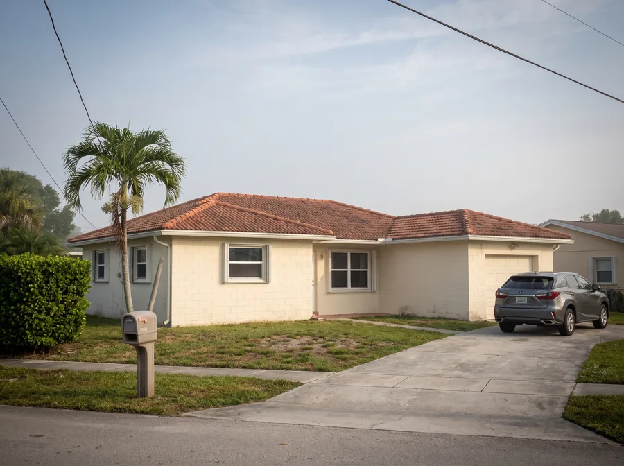 A typical South Florida single-story home with a tile roof, seen from the street.