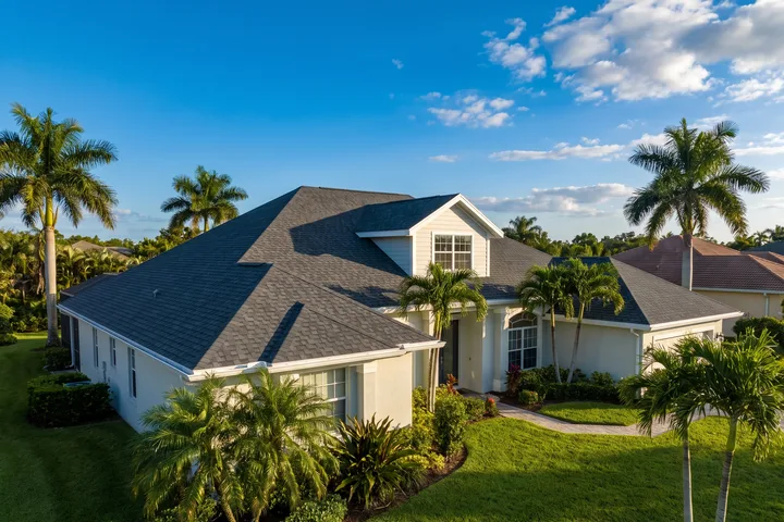 A South Florida home with a charcoal architectural shingle roof and a gable dormer.