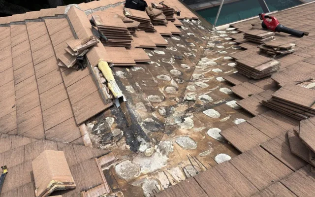 Tile removed to expose the area being repaired beneath the roof covering.