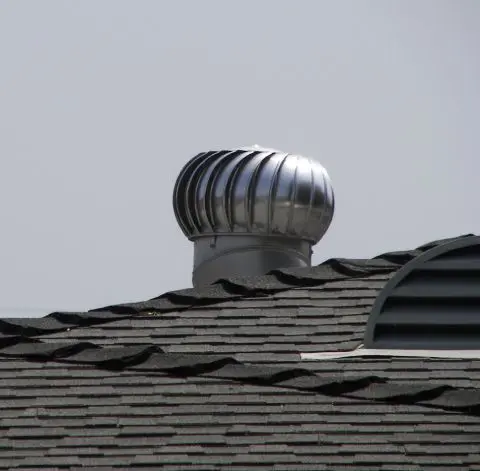 A turbine ventilator and a low-profile roof vent above asphalt shingles.